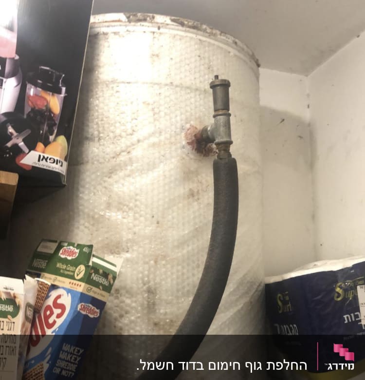 צינור מחובר לדוד מים עם חלודה